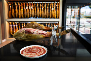 Plato con jamón ibérico y pieza de jamón en exhibición