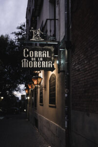 Cartel del Corral de la Morería iluminado en la noche