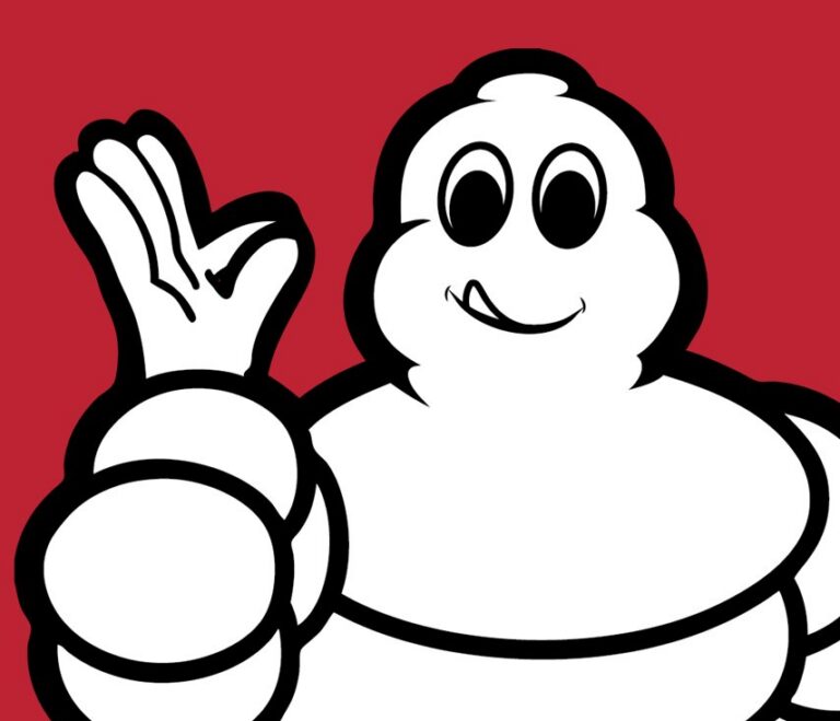 Personaje de Michelin saludando con una mano en fondo rojo