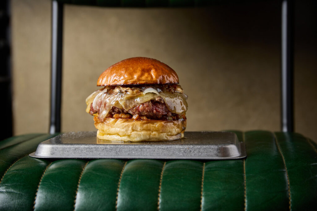 Hamburguesa La Perla de La Bistroteca sobre una bandeja metálica