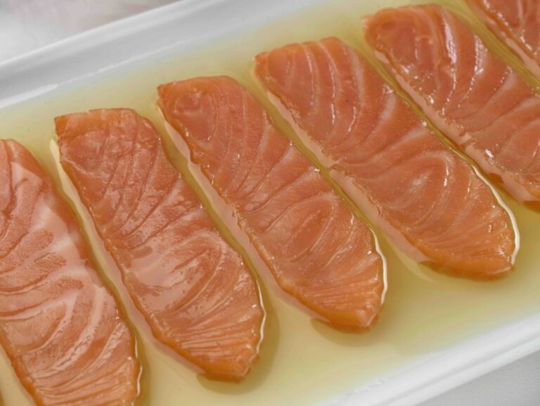 Lomos de salmón ahumado en aceite de oliva en un plato blanco