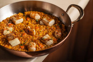 Plato de risotto con mariscos y pescado en un elegante recipiente
