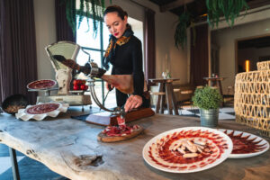 Mujer cortando jamón en un elegante restaurante de Madrid
