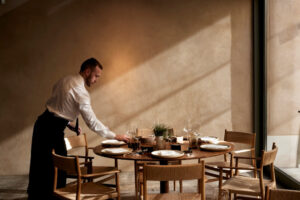 Un camarero preparando una mesa en un elegante restaurante.