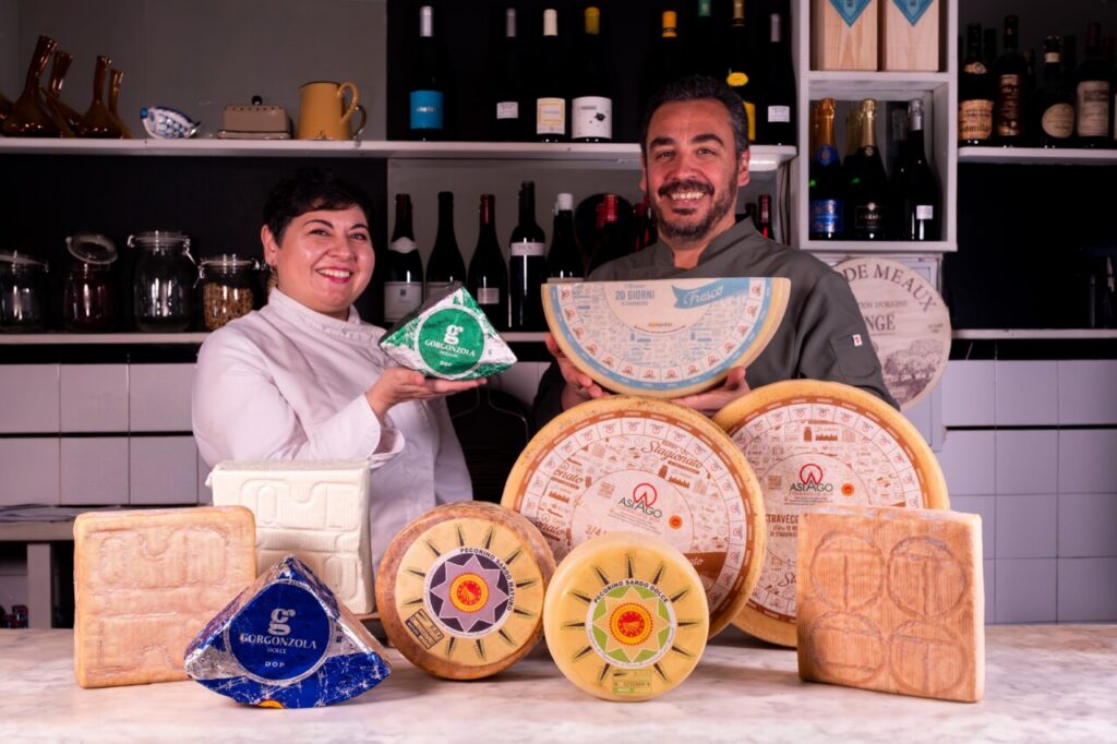 Chef y experto sosteniendo quesos italianos en restaurante