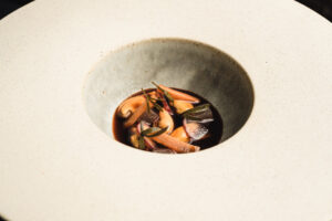 Plato de mejillones con salsa en un elegante plato blanco