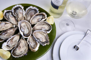 Bodegón de ostras frescas con limón y vino blanco