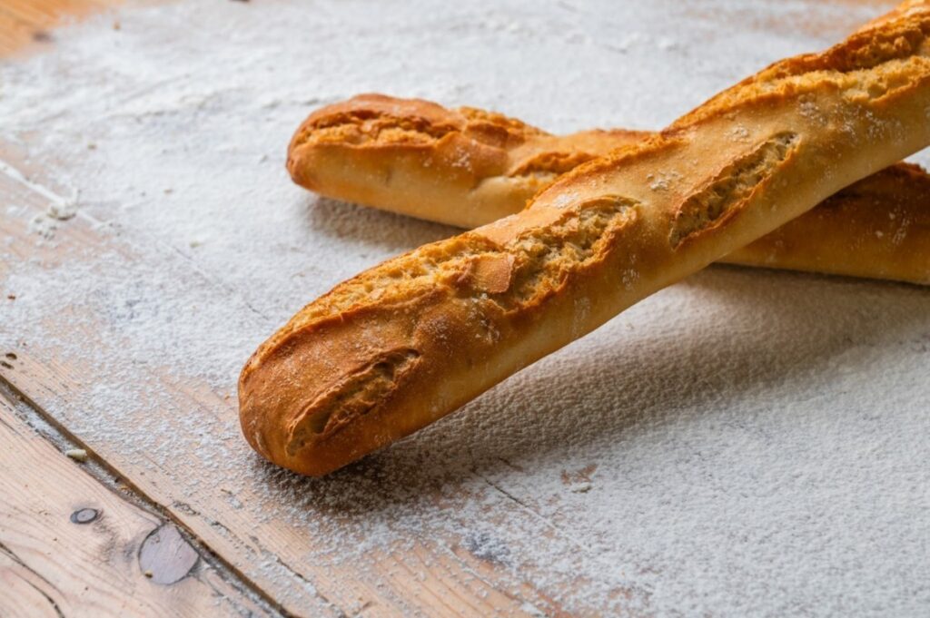 Barras de pan Espiga sobre una mesa de madera con harina