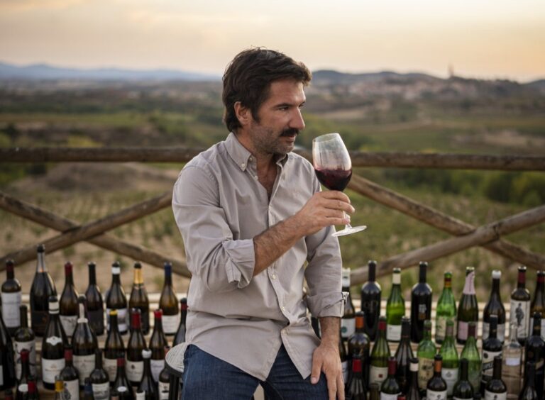 Richi Arambarri sosteniendo una copa de vino en un viñedo