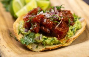 Taco con guacamole y carne en un plato de madera