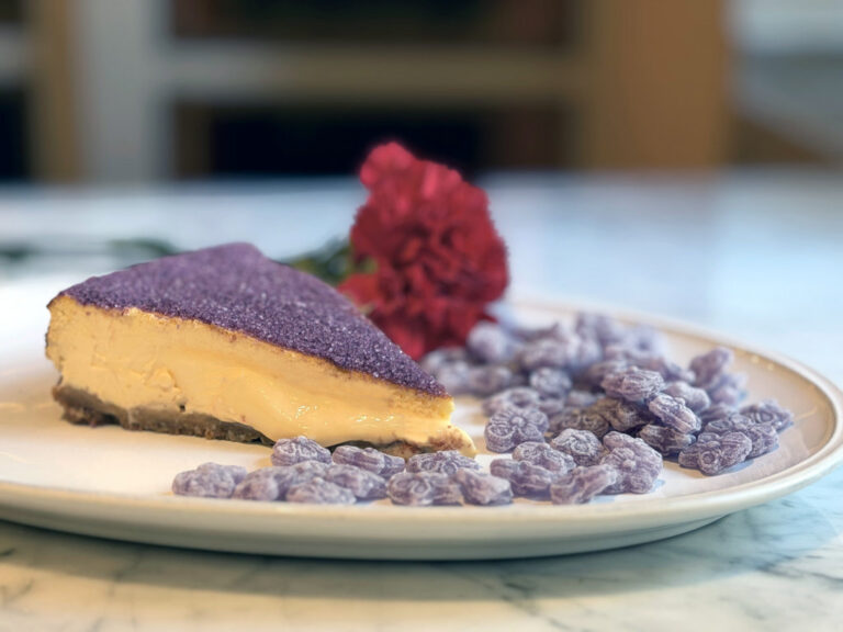 Tarta de queso decorada con caramelos de violeta y una flor
