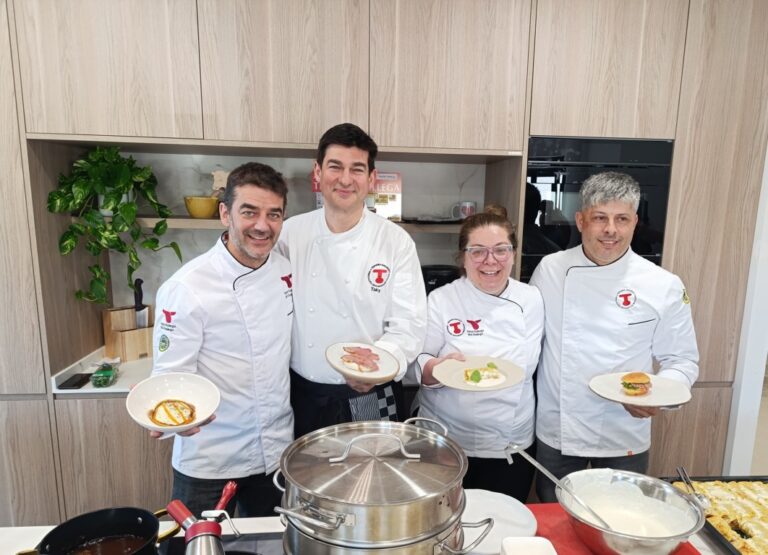 Cuatro chefs mostrando platos de ternera gallega en una cocina moderna