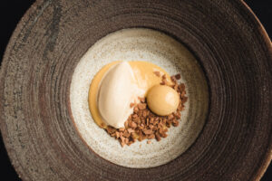 Postre de tocino de cielo con vinagres viejos de Jerez en un plato elegante
