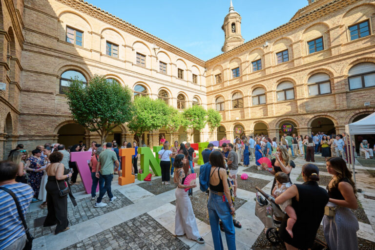 Asistentes disfrutando del Vinofest Navarra en Tudela con letras coloridas