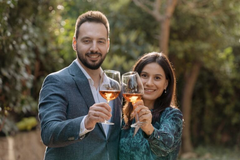 Pareja brindando con copas de vino en un entorno natural