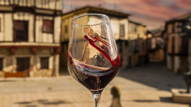 Copa de vino tinto con fondo de arquitectura tradicional
