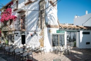 Exterior del Bar Guerra en Marbella con mesas y flores