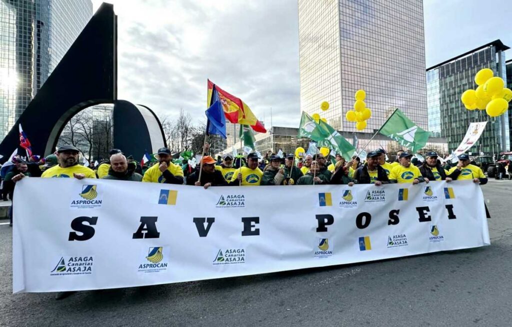 Manifestantes sosteniendo una pancarta en defensa del POSEI en Canarias
