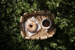 Donut de cocido vasco con café en una bandeja sobre hierbas