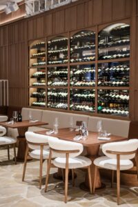 Interior del restaurante Nota Blu Brasserie con mesas y botellas de vino