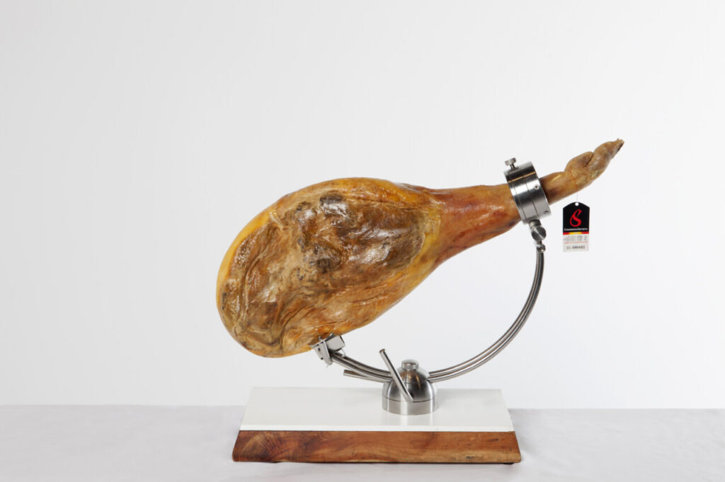 Jamón curado en soporte de exhibición con etiqueta del consorcio