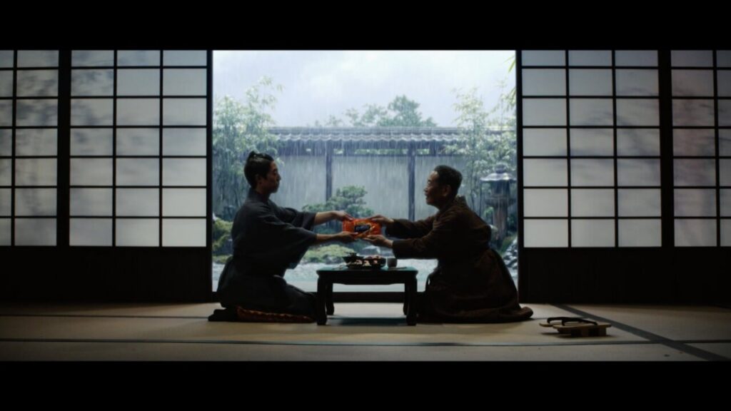 Dos personas en un ambiente japonés intercambiando barritas de surimi.