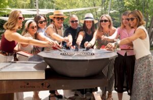 Grupo de mujeres disfrutando de una marbacoa con salmón en un ambiente festivo.