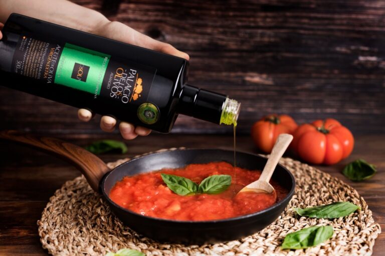 Botella de aceite de oliva virgen extra sobre una salsa de tomate