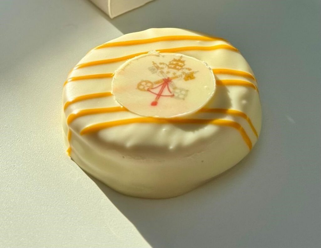 Postre Cor Unum decorado con chocolate blanco y amarillo