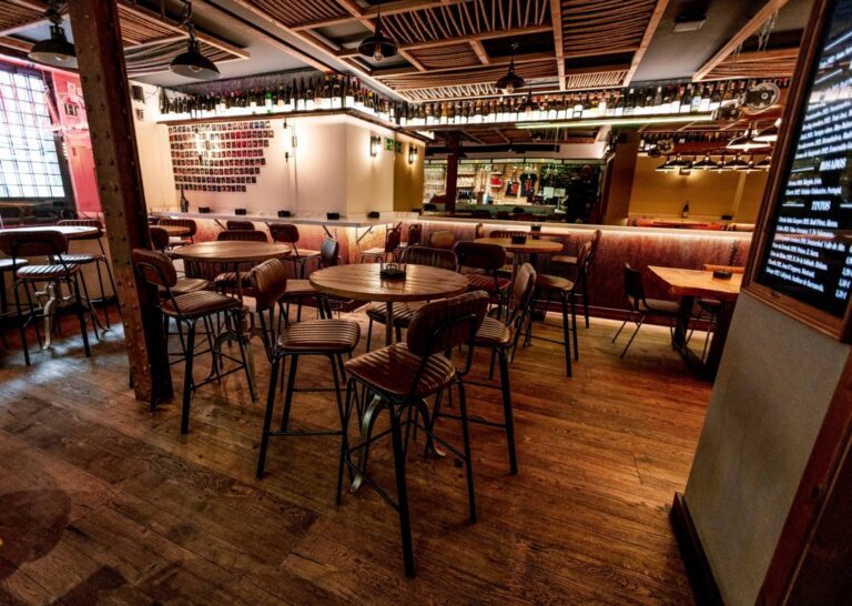 Interior del vinobar Caíño en Madrid con mesas y sillas