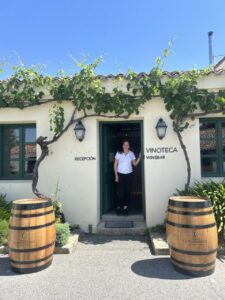 Mujer en la entrada de una vinoteca con barricas de vino