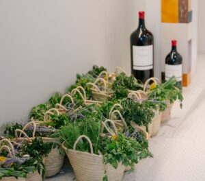 Cestas con hierbas frescas y botellas de vino en Abadía Retuerta