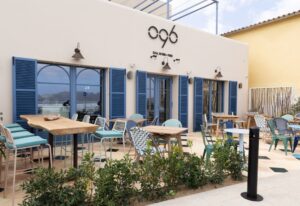 Exterior del restaurante o96 con mesas y sillas frente al mar en Pollença