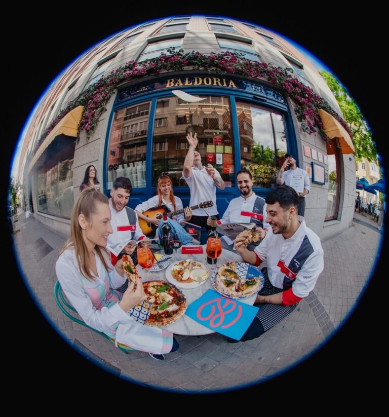 Grupo de personas disfrutando de pizza en Baldoria, Madrid.