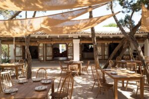 Terraza del restaurante Casa Jondal en Ibiza con mesas de madera