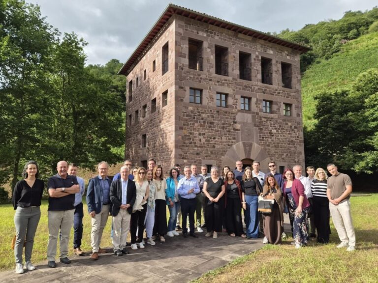 Grupo de personas reunidas frente a un edificio en un entorno natural