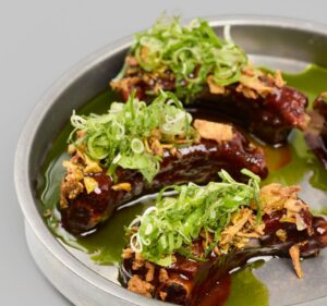 Costillas Baby Back Ribs al estilo malayo con cebollino y salsa