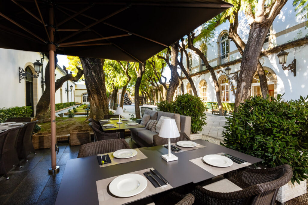 Terraza del nuevo Raw Bar en Toro Tapas con mesas y vegetación