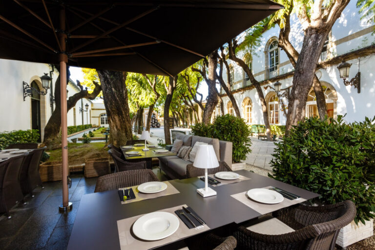 Terraza del nuevo Raw Bar en Toro Tapas con mesas y vegetación
