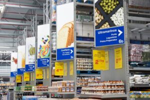 Pasillo de un supermercado con productos y señalización de categorías