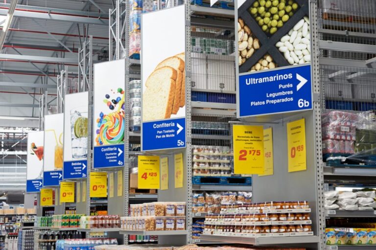 Pasillo de un supermercado con productos y señalización de categorías
