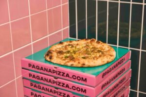 Pizza Pagana sobre cajas de pizza en un entorno moderno y colorido