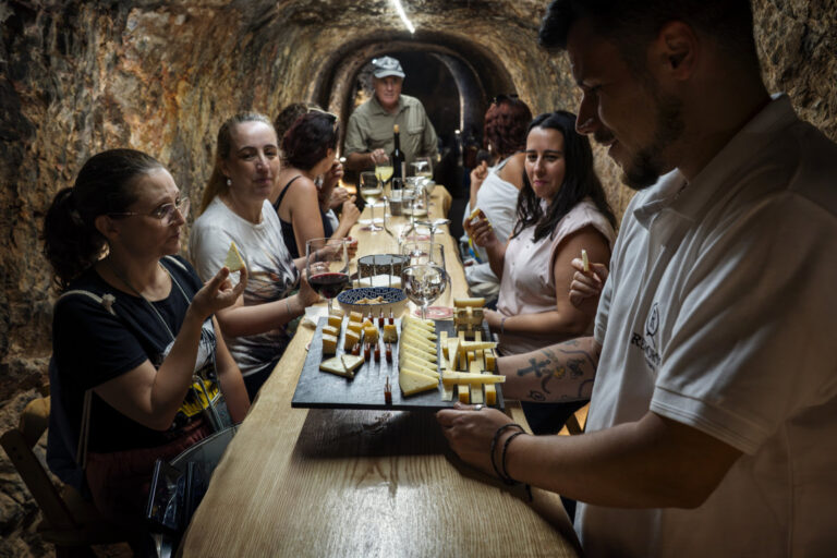 Cata de quesos en una cueva con visitantes disfrutando