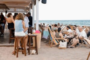 Personas disfrutando de una cata de vinos en la playa de Cullera