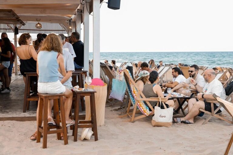 Personas disfrutando de una cata de vinos en la playa de Cullera