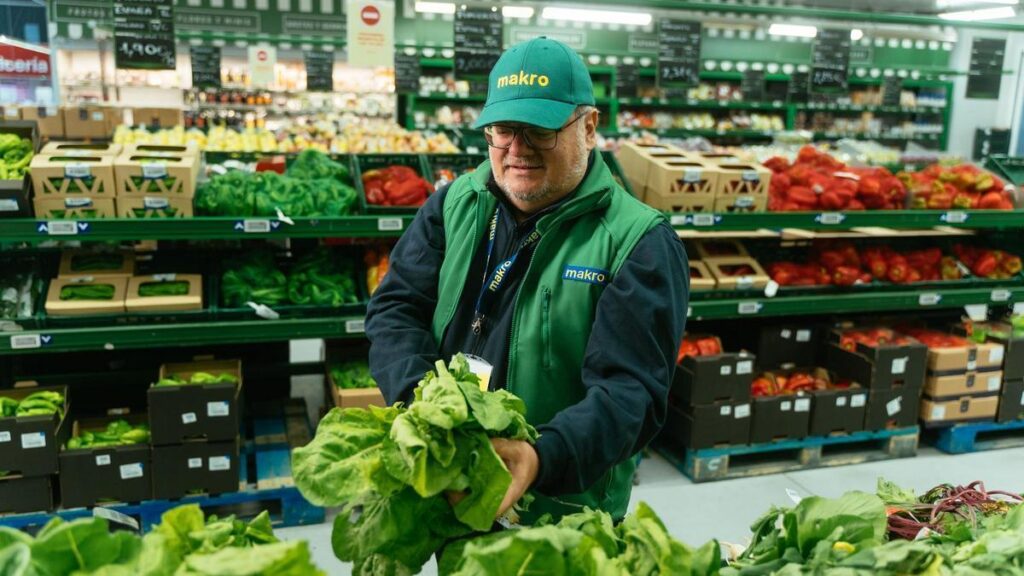 Empleado de Makro seleccionando verduras frescas en el supermercado