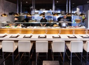 Interior del 99 Sushi Bar con chefs preparando sushi y platos japoneses