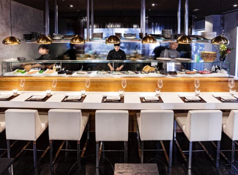 Interior del 99 Sushi Bar con chefs preparando sushi y platos japoneses