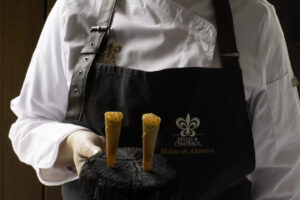 Cono de trucha con emulsión de cebollino presentado por un chef