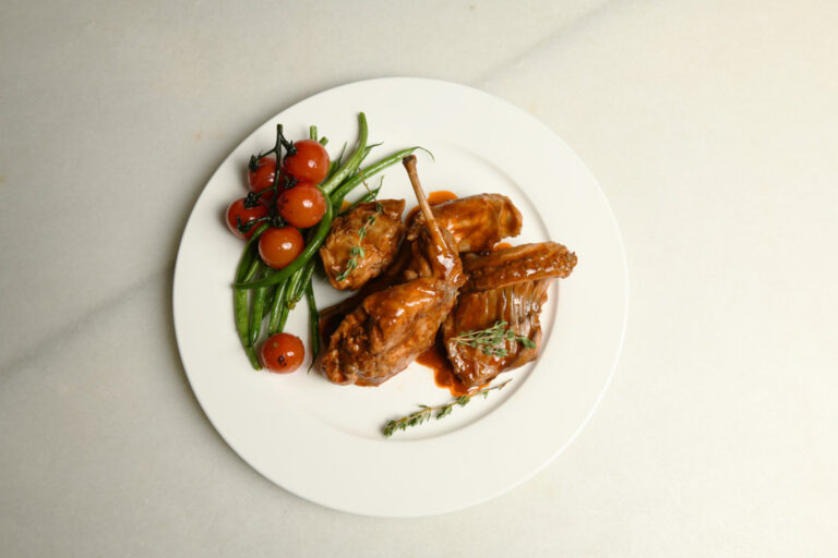 Plato de carne de conejo en adobo con guarnición de verduras